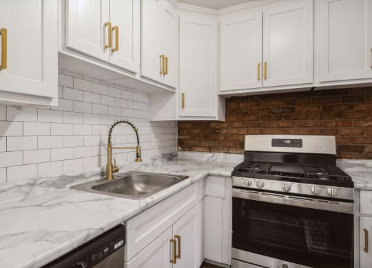 a kitchen with white cabinets and white marble countertops