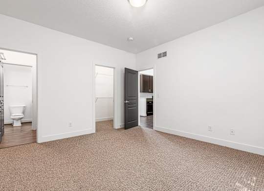 A carpeted room with a toilet and a black cabinet. at River View at Bexley Apartments, Ohio, 43209