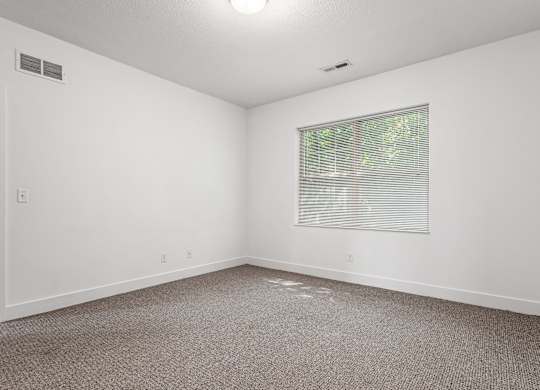 A room with a window and a carpeted floor. at River View at Bexley Apartments, River View at Bexley, Ohio