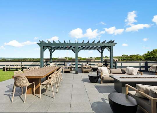 A patio with a table and chairs under a pergola.
