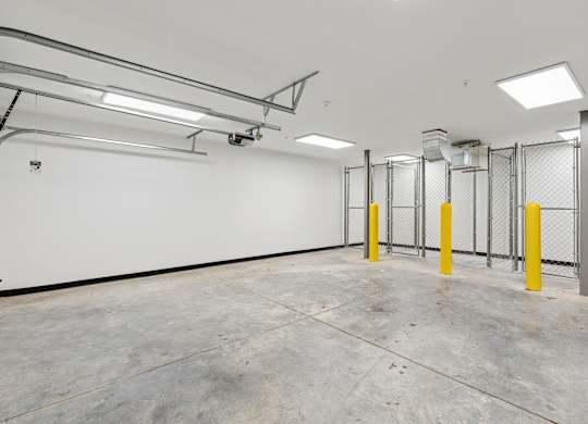 A large, empty room with a concrete floor and white walls.