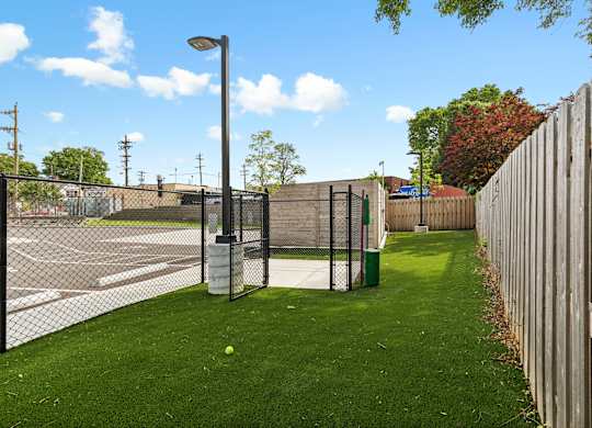 A green lawn with a fence and a lamp post.