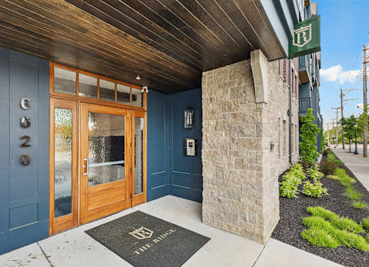 The entrance to a building with a green sign above it.