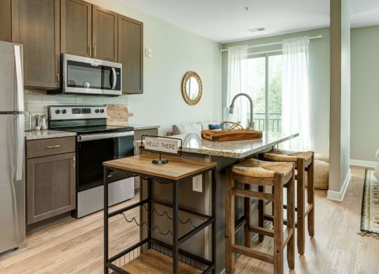 a kitchen with an island with wooden stools at Adelphi Quarter, Columbus