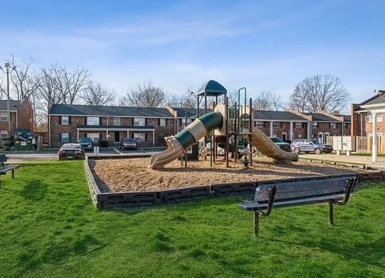 a playground with two slides and a bench