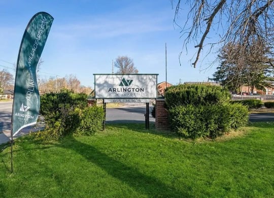 a sign in the grass with a tree in the background