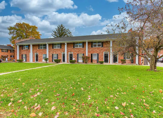 a large brick building with a green lawn in front of it
