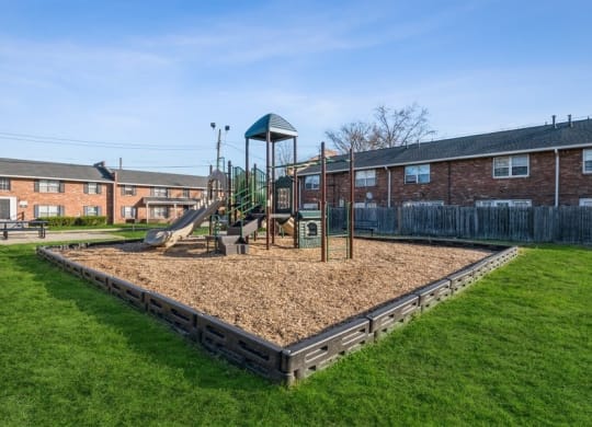 a playground with a swing set in the middle of a grassy area