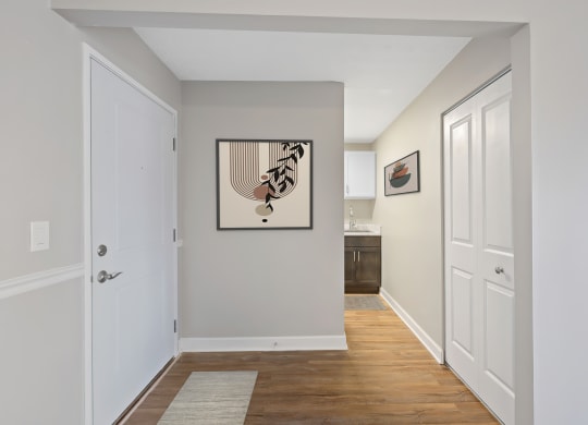 a hallway with white doors and a painting of a bird on the wall