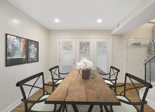 a dining room with a wooden table and black chairs at Harpers Point Apartments, Cincinnati, Ohio