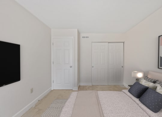 a bedroom with two doors and a tv on the wall at Harpers Point Apartments, Cincinnati, OH
