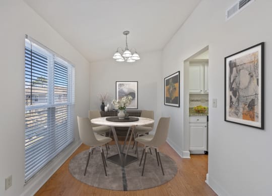 a dining room with a table and chairs and a large window at Harpers Point Apartments, Ohio