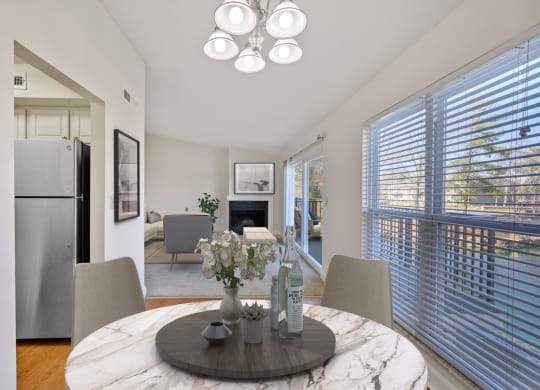 a dining room with a round table with four chairs and a fireplace in the background at Harpers Point Apartments, Cincinnati, OH
