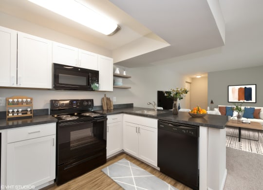 a kitchen with white cabinetry and black countertops at 7 Pointe Apartments, Indiana