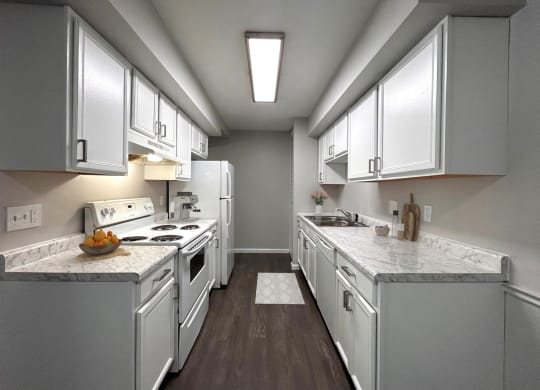 a kitchen with white appliances and marble counter tops