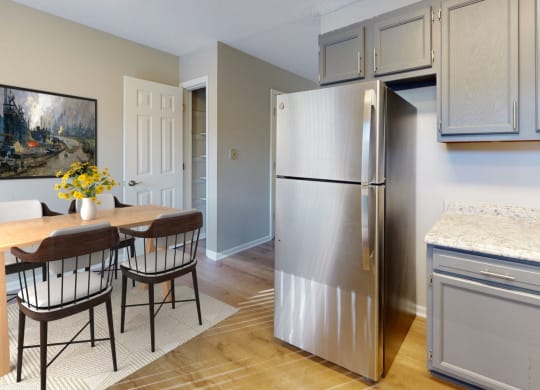 a kitchen with a stainless steel refrigerator and a table and chairs