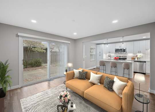 a living room with a couch and a kitchen in the background at Indian Creek Apartments*, Ohio