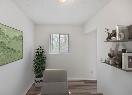 A room with a painting, a plant, and a chair.