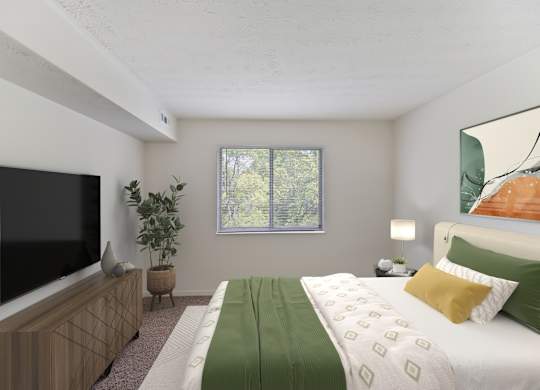 A bedroom with a bed, a television, and a plant.