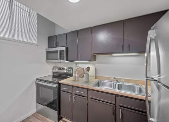 A kitchen with brown cabinets and stainless steel appliances.