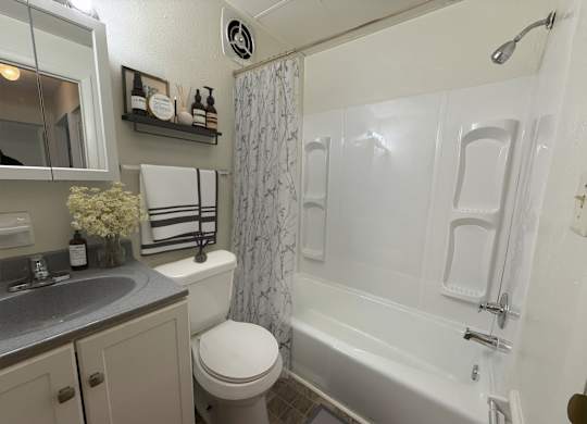 A white bathroom with a toilet, sink, and bathtub.