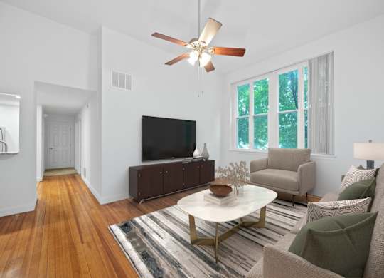 A living room with a white ceiling fan and a white coffee table.