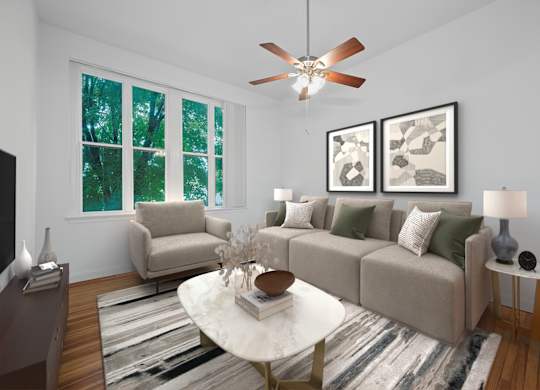 A living room with a beige couch, a white coffee table, and a ceiling fan.