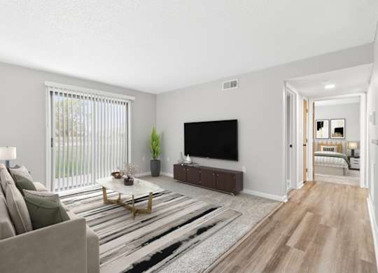A living room with a couch, a coffee table, and a television.