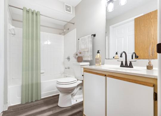 A white toilet sits in a bathroom next to a sink.