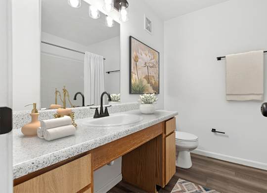 A bathroom with a white countertop and a towel hanging on the wall.