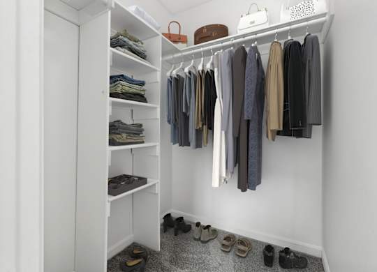 A white closet with clothes and shoes.
