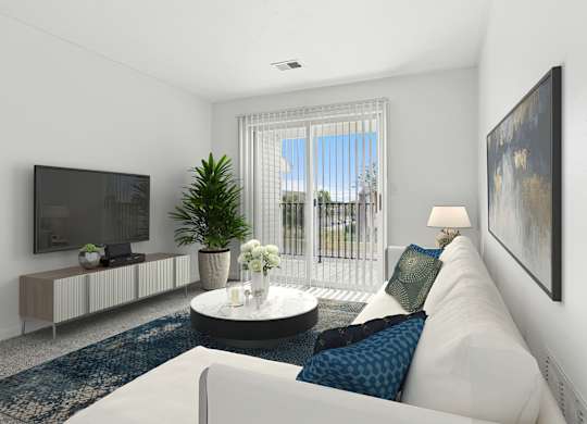 A living room with a white couch, a television, a plant, and a painting on the wall.