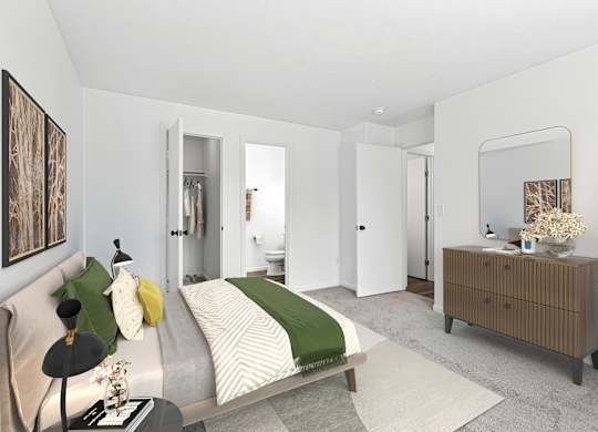 A bedroom with a bed, nightstand, and a plant.