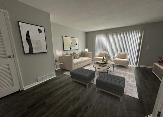 A living room with a grey couch, a black ottoman, and a painting on the wall.