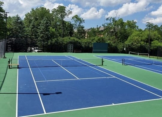 a blue and green tennis court with a blue sky