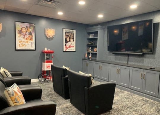 a living room with chairs and a television