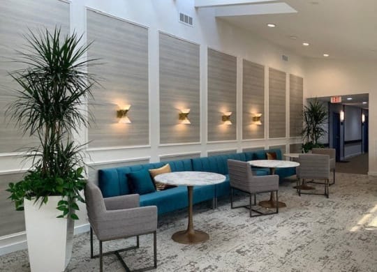 a lobby with a blue couch and tables and chairs