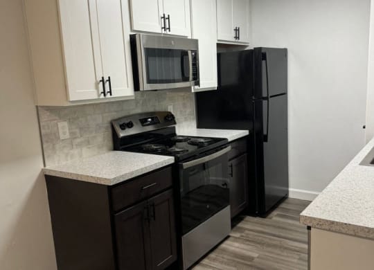 Kitchen with black appliances and white cabinets  at Hilltop Apartments, Ohio