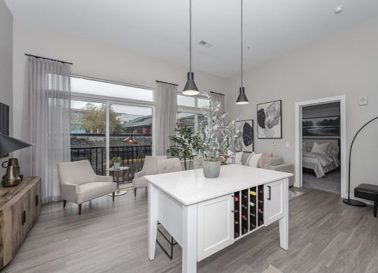 Pet-Friendly Apartments in West Chester, OH - Liberty Center - Living Room with Floor-to-Ceiling Windows, Wood-Style Floors, and Hanging Light Fixtures