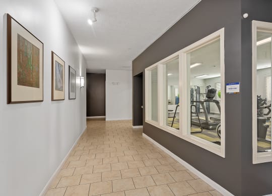 a resident fitness center with mirrors on the wall and a tiled floor