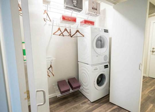 A small laundry room with a washer and dryer stacked on top of each other.at Sky Central, Cincinnati, 45202