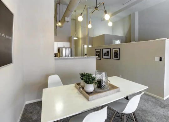 a dining room with a white table and chairs at The Lofts at Shillito Place, Cincinnati, Ohio