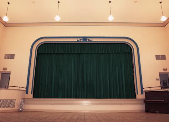 A stage with a green curtain and a blue frame.