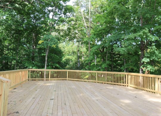 a covered deck with trees in the background at Rivers Edge Apartments and Townhomes, Ohio, 45405