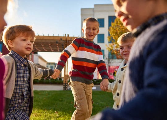 a group of young boys holding hands and laughing
