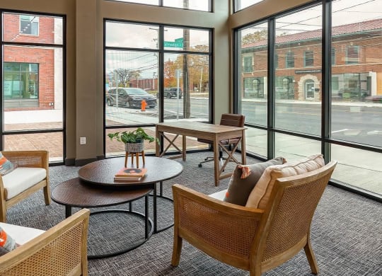 a lobby with chairs and tables and large windows at Adelphi Quarter, Columbus