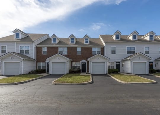 a row of houses with white roofs on a street at Traditions at Slate Ridge, Reynoldsburg, OH