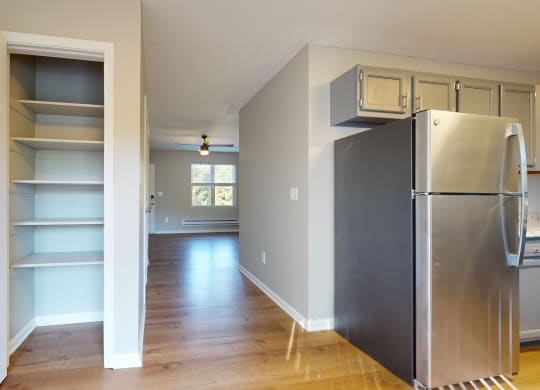 a renovated kitchen with a stainless steel refrigerator and shelves