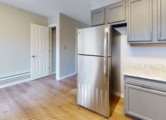 an empty kitchen with a stainless steel refrigerator