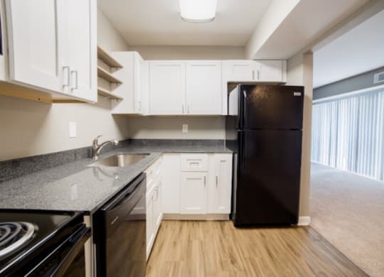 an empty kitchen with black appliances and white cabinets at 7 Pointe Apartments, Indianapolis